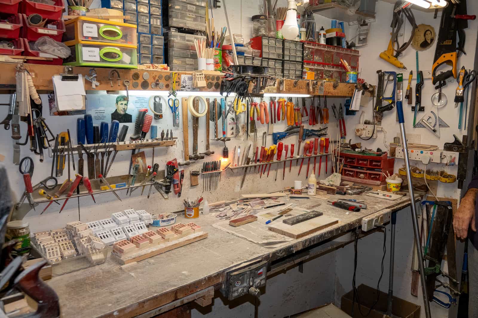 A large organized workshop with tools and supplies across the back wall