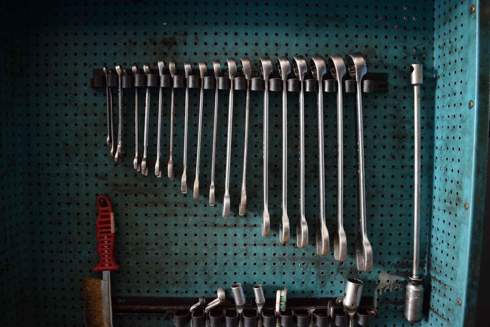Wrenches arranged on a perforated tool board in a workshop