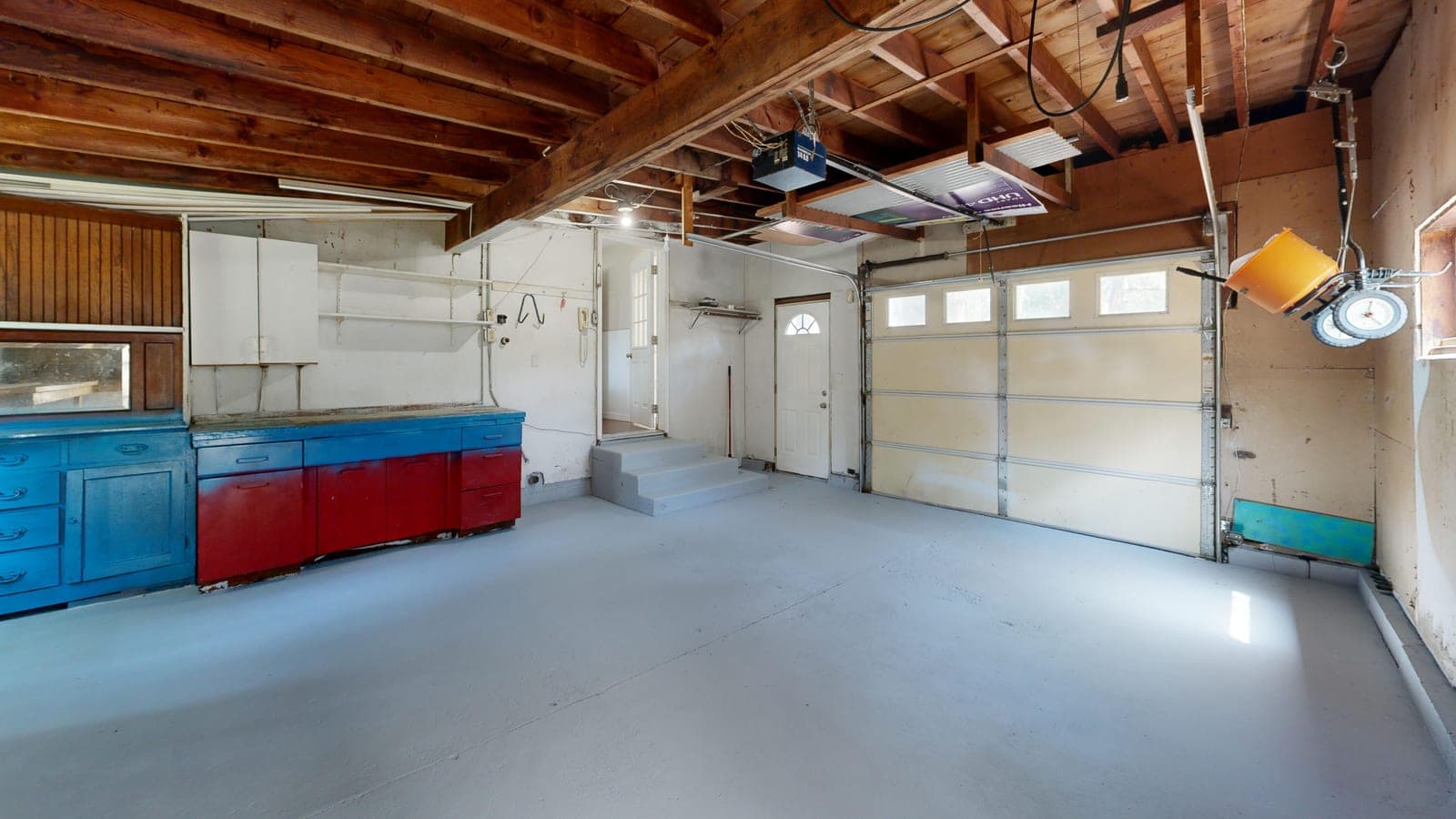 An open garage with storage cabinets along the wall
