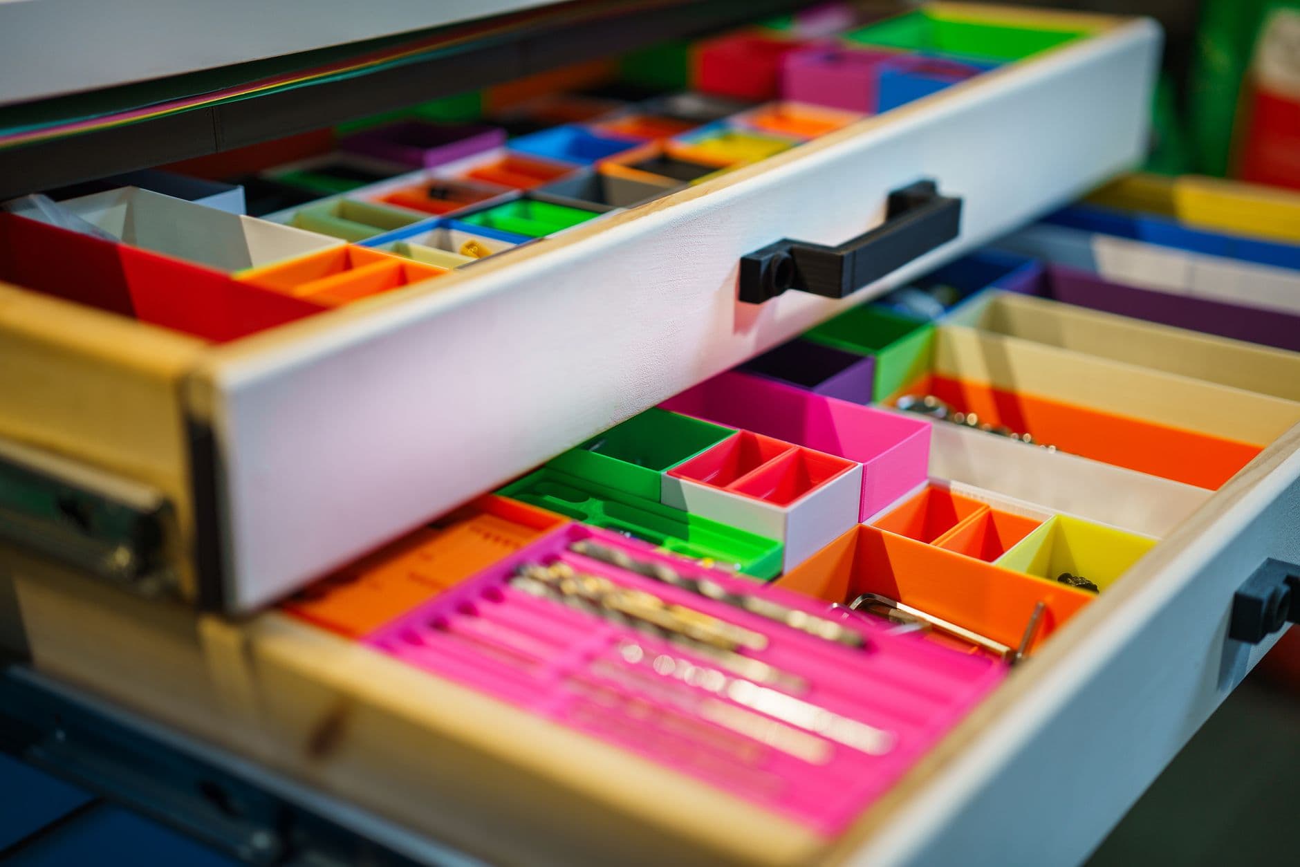 A drawer fitted with colored compartments holding small items