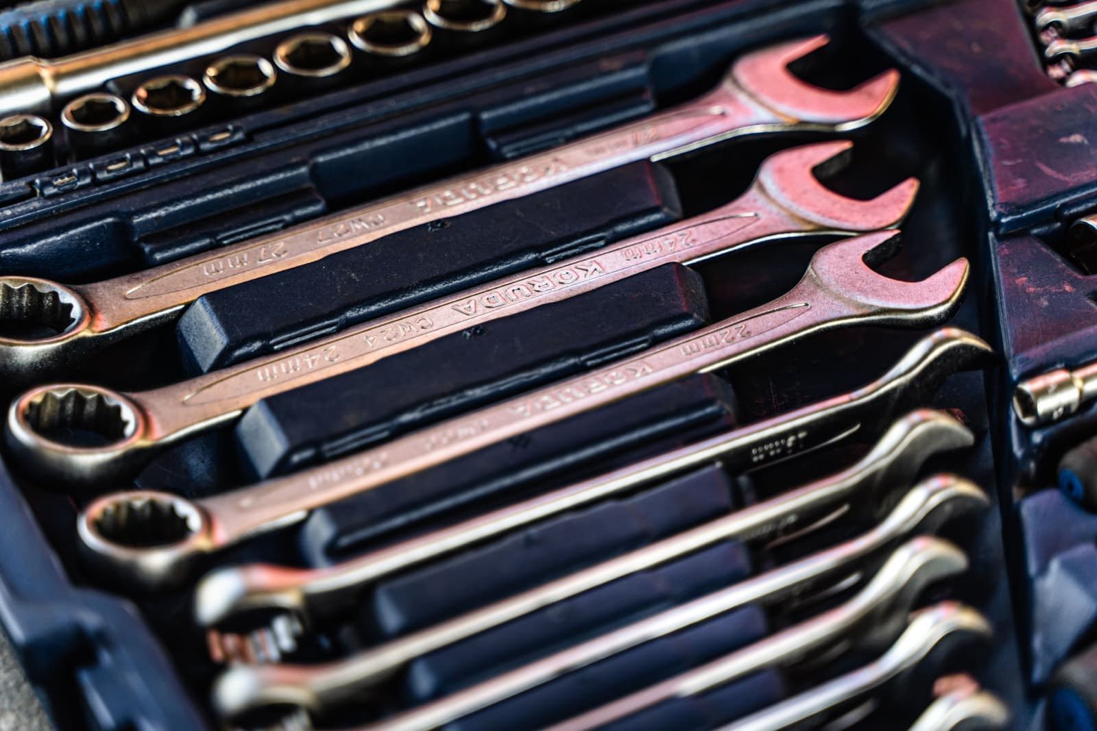A set of wrenches laid in order inside a toolbox