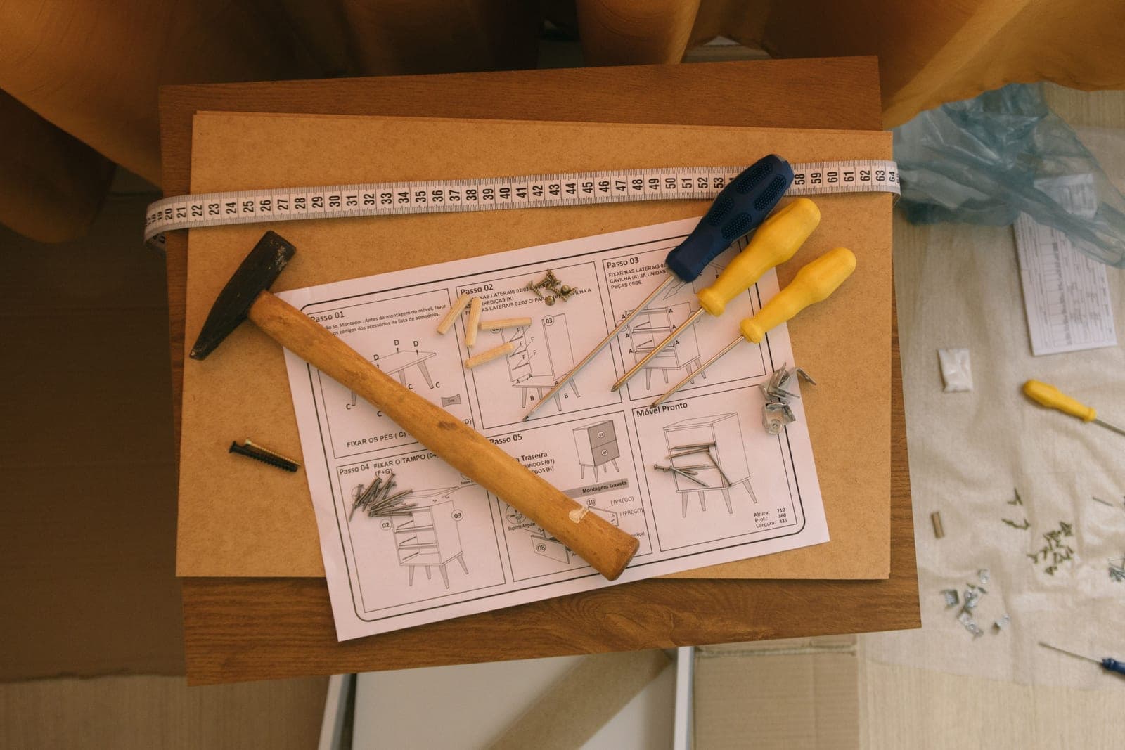 Assembly instructions and a screwdriver on a cabinet surface, seen from above
