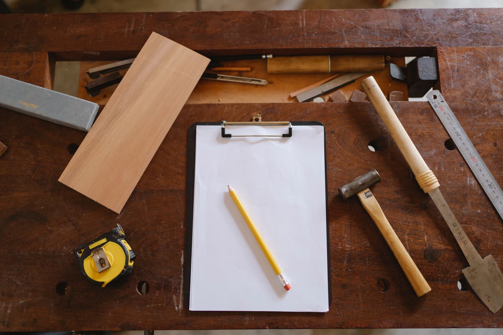 Carpentry tools laid out flat on a wooden workbench