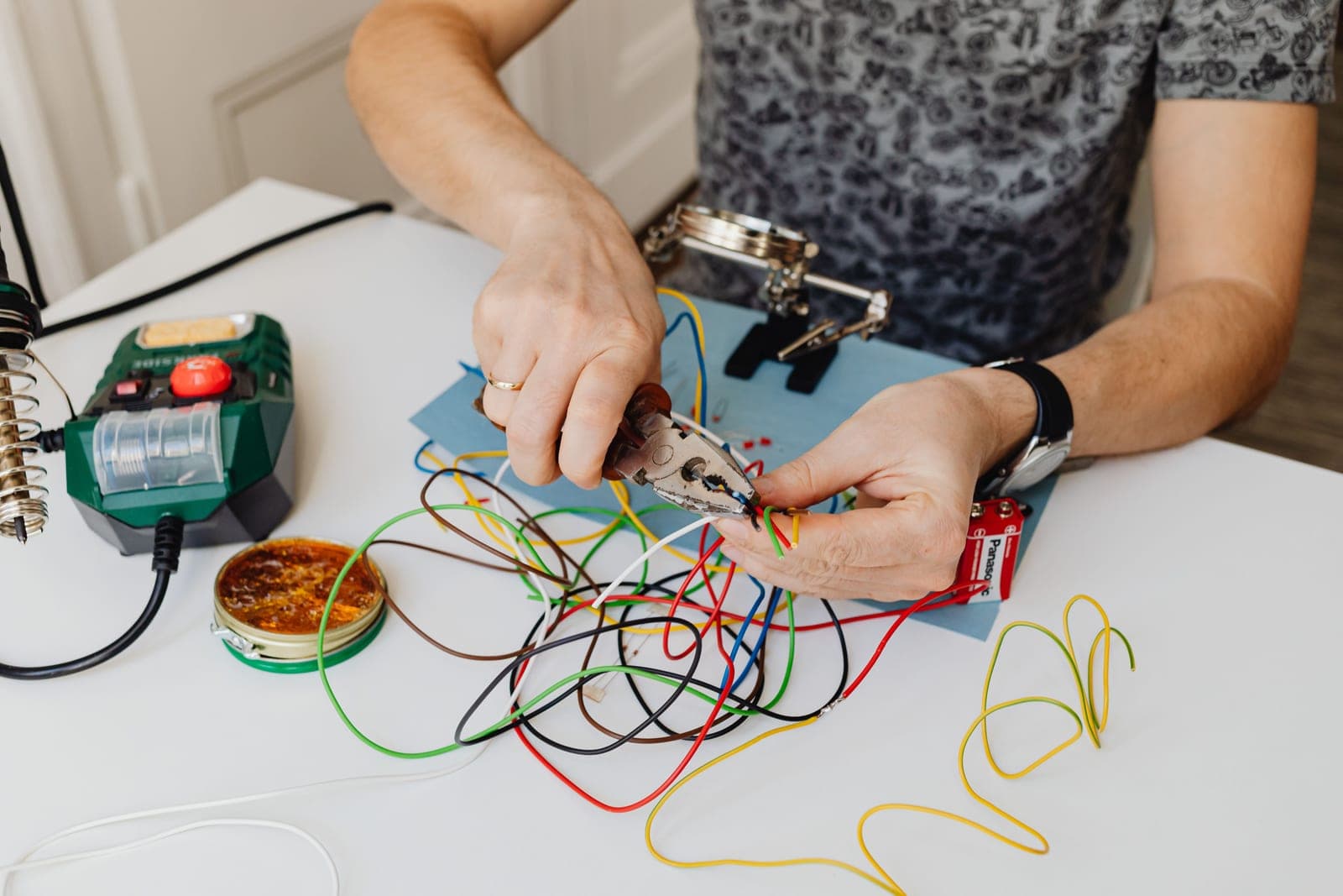 A technician cutting and sorting colored wiring with pliers