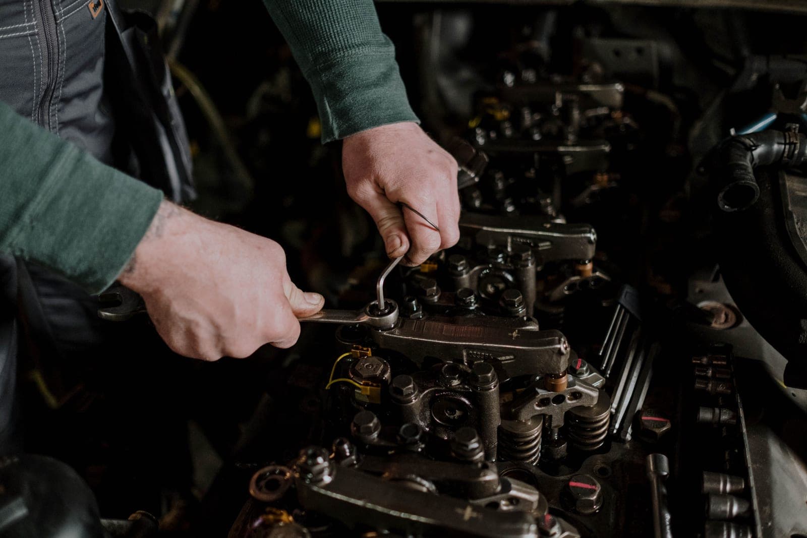 A mechanic using hand tools on an engine, photographed close up