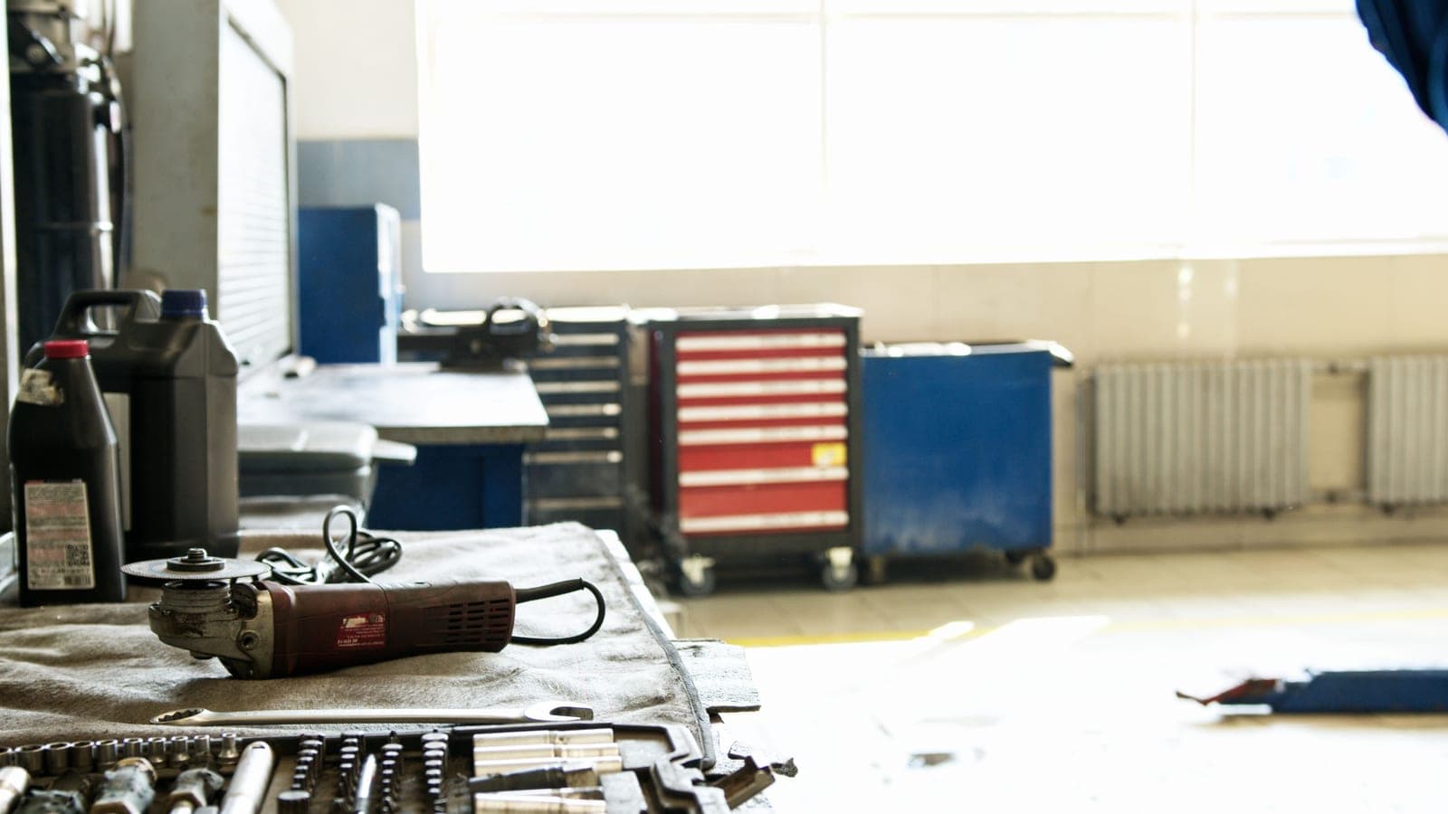 An organized workshop bay with an angle grinder and tool storage alongside