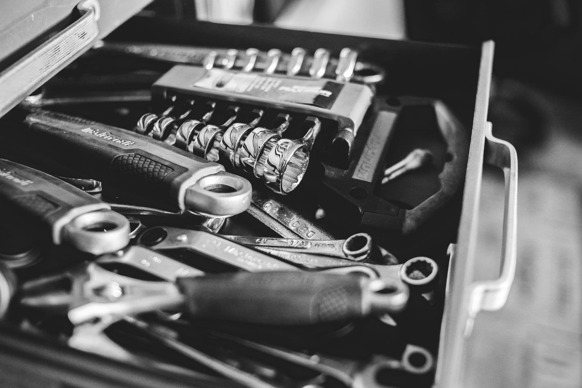 An open cabinet drawer holding an assortment of repair tools, seen from above