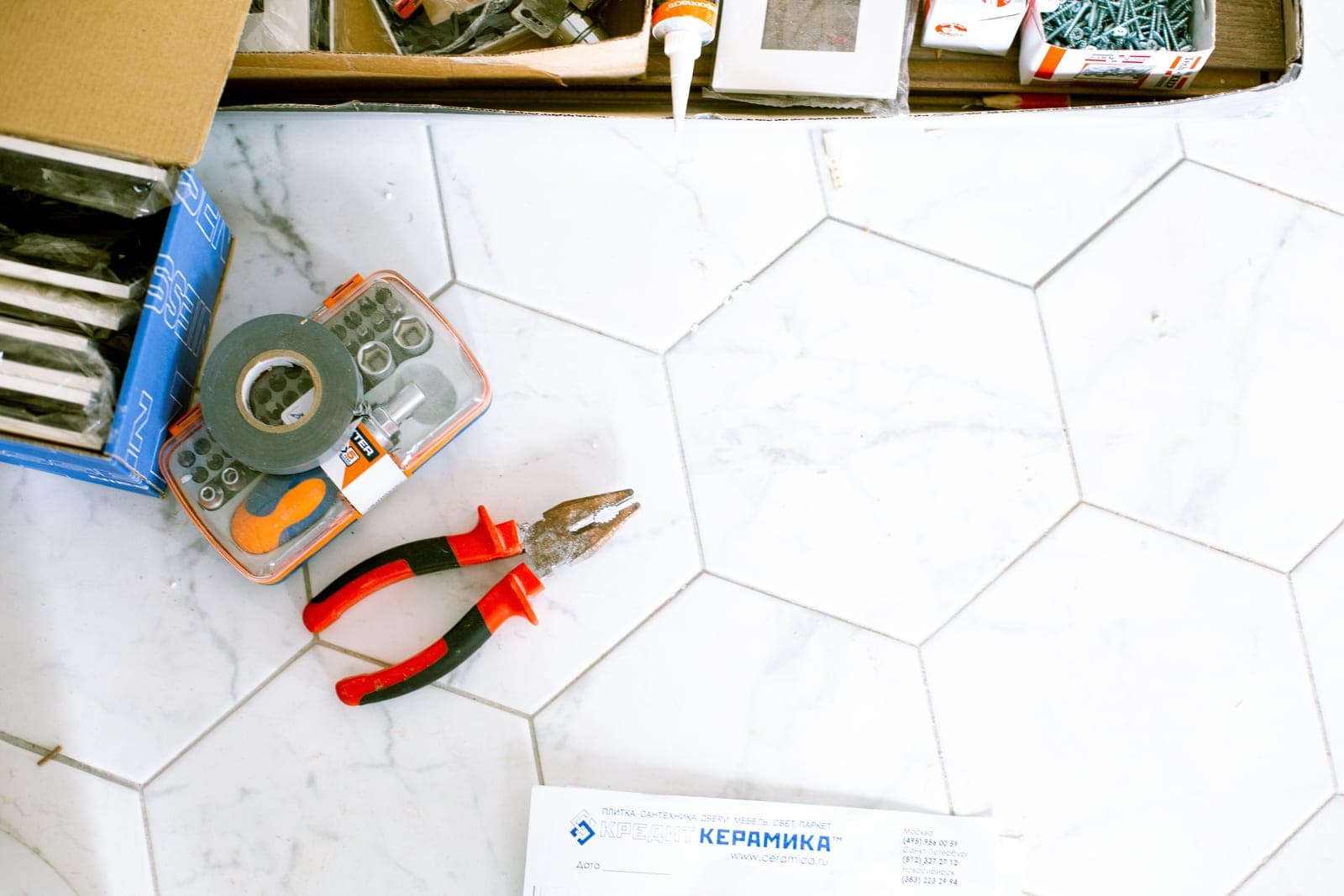Renovation tools laid out on a tiled floor ready to be packed