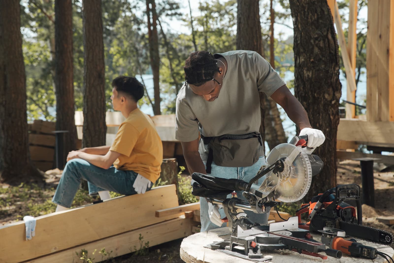 Two people working with carpentry tools at an outdoor job site