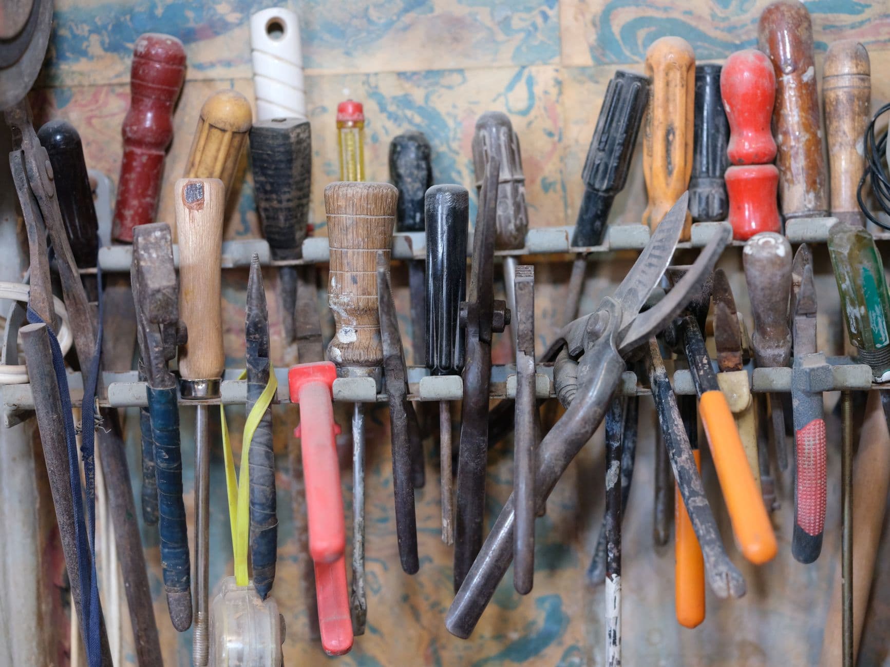 Hand tools arranged on a workshop storage rack