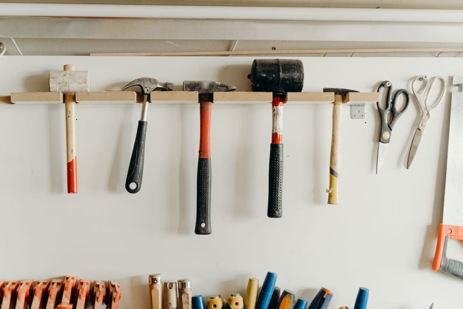 Hand tools hung in order on a workshop wall above a bench