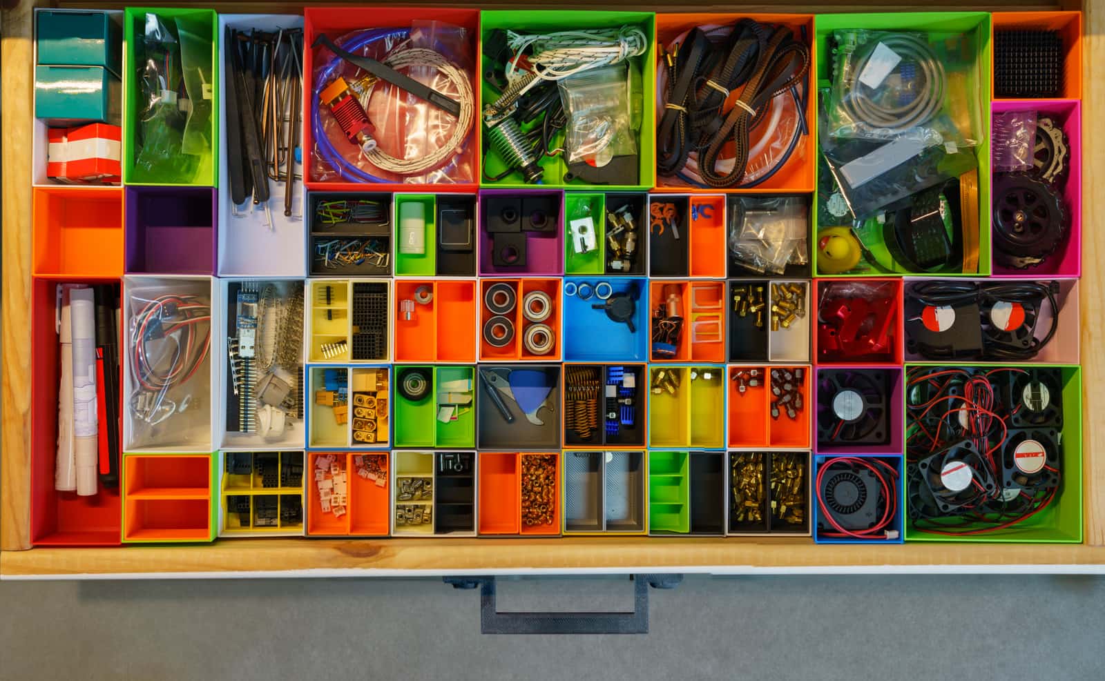 A shallow drawer seen from above, divided into containers of small parts
