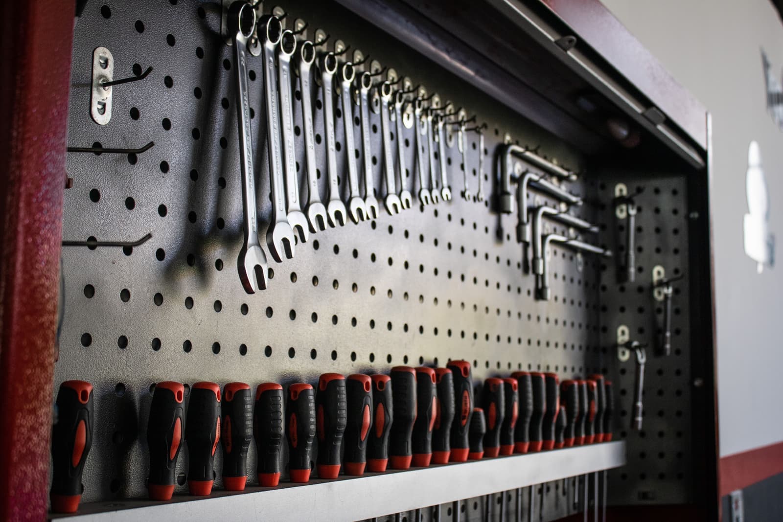Hand tools arranged in rows on a workshop pegboard